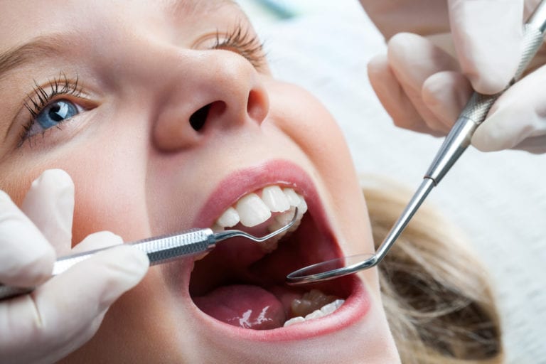 pediatric dentist examining baby teeth